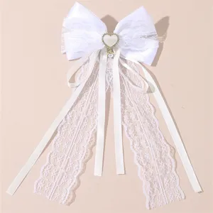 Exquisite white lace hair bow detail, featuring delicate ribbon streamers and pearl heart pendant.