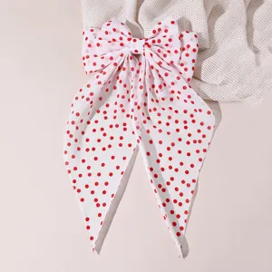Red polka dot bow hair clip with long tails, sweet fabric spring clip detailed view.