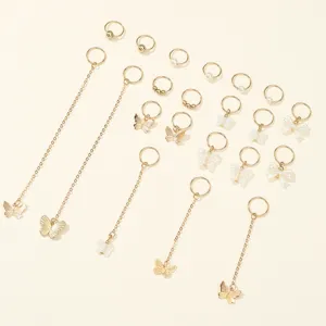 Close-up detail of gold butterfly chain dreadlock hair rings, DIY styling accessories set.