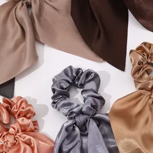 Vue détaillée de chouchous en satin avec rubans courts, tissu doux, accessoires de coiffure.