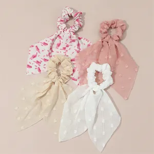 Vue détaillée de chouchous en mousseline française, élégants élastiques en tissu à longs pans.