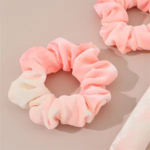 Detailed closeup view of soft tie dye plush hair scrunchies and curling rod accessories.