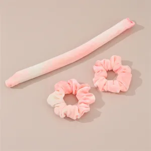 Detail view of pink tie-dye heatless curling rod set with scrunchies, soft velvet fabric texture for hair styling.