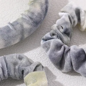 Detailed close-up of velvet tie-dye heatless curling rod and scrunchies set texture.