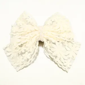 Detailed view of off-white lace bow hair clip with elegant pearl center, perfect accessory.