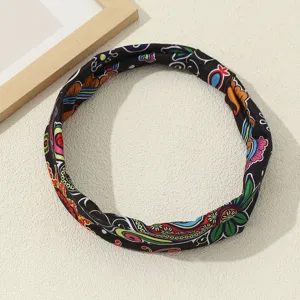 Close-up of the vintage ethnic floral print and soft fabric texture on the black headband.