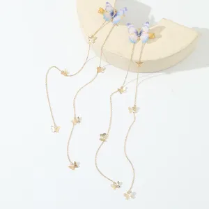 Detailansicht der lila Schmetterling Haarspange mit Gold Metallketten und Quasten.