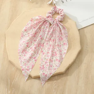 Detailed view of the pink floral hair scrunchie with long mesh ribbons, elegant styling.