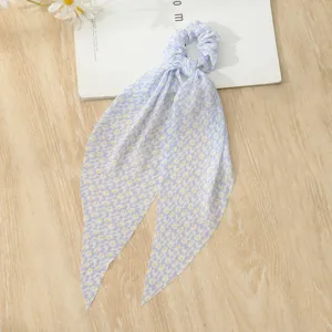Blue floral scrunchie with long ribbons hair tie detail view showing fabric pattern.