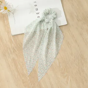 Detailed close-up shot of a light green floral hair scrunchie with long ribbons for women.