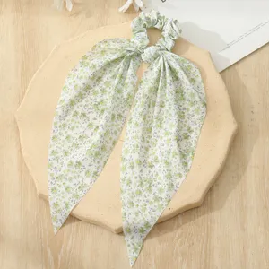 Green floral hair scrunchie with long ribbons, elegant mesh hair accessory detail shot.