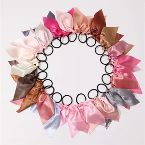 Vue détaillée d'élastiques à cheveux en satin coloré avec de courts rubans, plusieurs teintes.