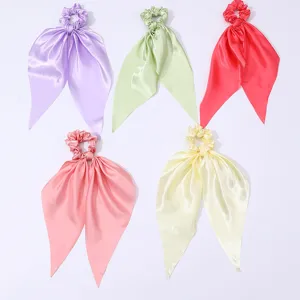 Vue détaillée de cinq chouchous en satin coloré avec des rubans fluides et doux pour un style quotidien.