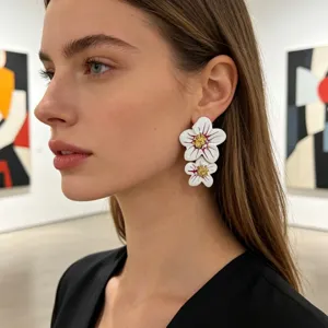Élégantes boucles d'oreilles doubles fleurs blanches avec détails dorés pour femmes.