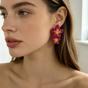 Gros plan détaillé de boucles d'oreilles fleuries en résine magenta, style chic et unique.