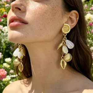 Detalle en primer plano de pendientes de concha estilo resort de verano con perlas.