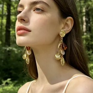 Pendientes de concha dorada y lágrima de ámbar, ideales para estilo de verano.