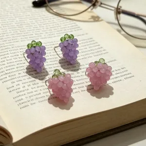 Détail de boucles d'oreilles grappe de raisin en perles avec des motifs de fruits mignons.