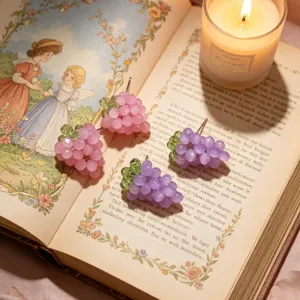 Vue detaillee de jolies boucles dorees en perles de raisin faites main en rose et violet.
