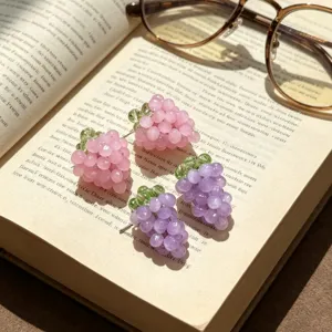 Boucles d'oreilles en perles forme de raisin gros plan détaillé sur un vieux livre.