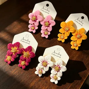 Magnifiques boucles d'oreilles fleurs en émail coloré avec cœurs brillants sur cartes.