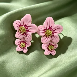 Boucles d'oreilles fleurs en émail rose pour femmes, design double avec pistils dorés.