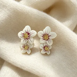 Belles boucles d'oreilles clous de fleurs en émail avec double pétaux et centre doré.