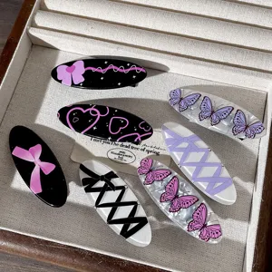 Primer plano detallado de pinzas para el cabello ovaladas con lazos y mariposas moradas.