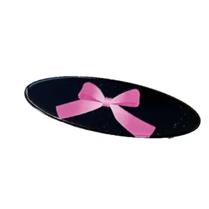 Elegante pinza de pelo ovalada negra con lazo rosa como accesorio de moda ideal
