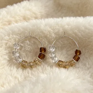 Gradiënt kristal kraal creolen met heldere, gouden en bruine kubusvormige kralen op zilver.