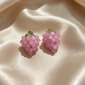 Détail des boucles d'oreilles clous raisin rose fait main, jolis bijoux de fruits.