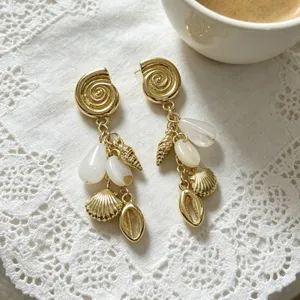 Primer plano pendientes concha perla dorada, joya tendencia moda vacaciones playa.