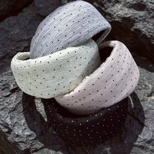 Primo piano dettagliato di fasce per capelli larghe plissettate a pois in chiffon morbido.