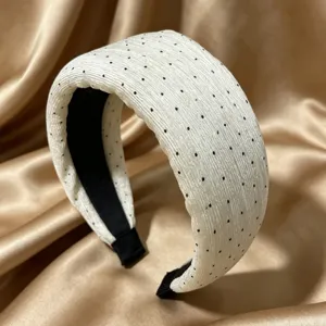 Elegante cerchietto largo bianco a pois neri con texture plissettata per look alla moda.