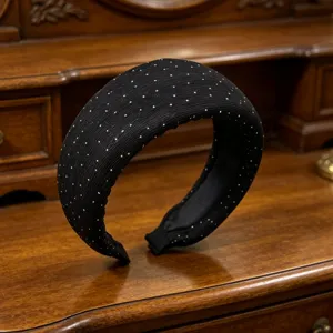 Primo piano dettagliato di un cerchietto largo nero a pois bianchi, stile elegante.