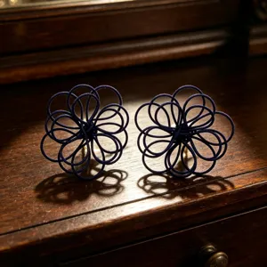 Exquisite dark blue woven flower stud earrings, elegant handmade botanical jewelry detail.