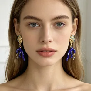 Prachtige blauwe koraal schelp oorbellen met goudafwerking en kristallen, elegant detail.