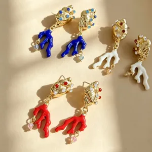 Gedetailleerd overzicht van gekleurde geëmailleerde schelp koraal oorbellen, elegante sieraden close-up.
