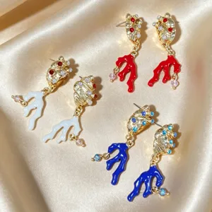 Detailopname van kleurrijke geëmailleerde koraal schelp lange kwast oorbellen details.