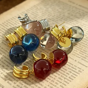 Gros plan de boucles d'oreilles créoles boule en cristal coloré, style français élégant.