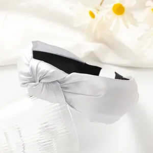 Close-up detail shot of a stylish silver grey knotted wide headband, elegant fabric texture.