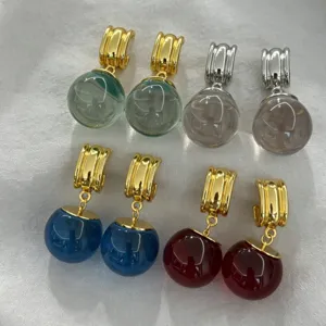 Boucles d'oreilles créoles boule de cristal colorées style français, détail de bijoux.
