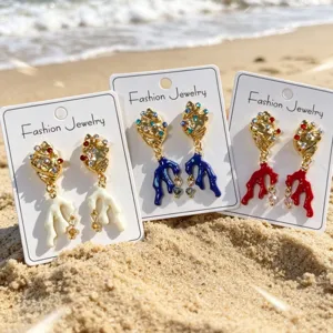 Gouden schelp koraal oorbellen met kleurrijke strass steentjes voor detailweergave.