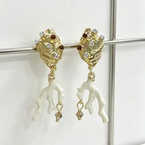 Elegante gouden schelp en witte koraal tak hangende oorknoppen met sprankelende kristallen.