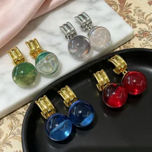 Vue détaillée des boucles d'oreilles créoles boule de cristal colorée style Monet.
