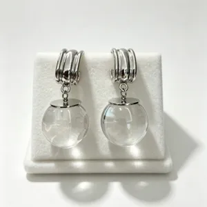 Vue détaillée de boucles d'oreilles créoles argentées avec sphères en verre, élégant.