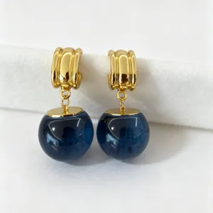 Boucles d'oreilles créoles dorées de style français avec sphères en cristal bleu foncé.