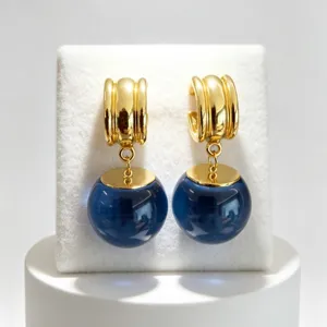 Boucles d'oreilles créoles dorées de style français avec pendentifs boule en cristal.
