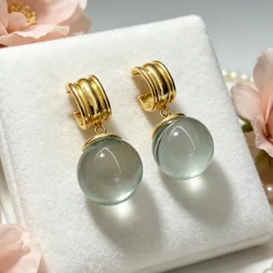 Gros plan detaille de boucles doreilles dorees en forme de C avec des perles de cristal.