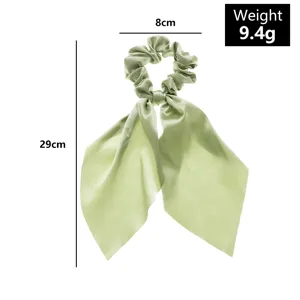 Detail view of light green satin hair scrunchie with long ribbon, showing size dimensions.